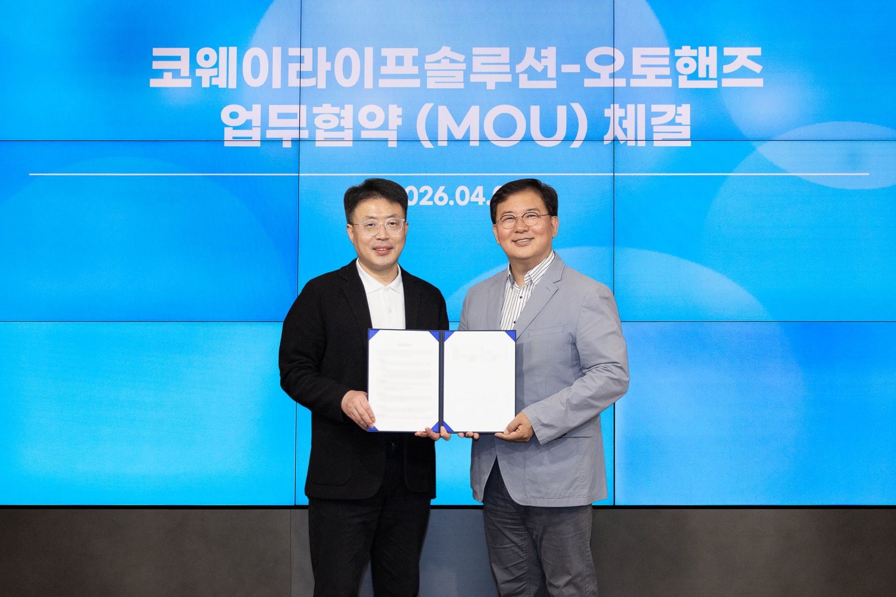 2026년 4월 7일 서울 구로구 지타워에서 진행된 업무협약식에서 김명곤 코웨이라이프솔루션 대표이사(왼쪽)와 김성준 오토핸즈 대표이사(오쪽)가 기념 촬영을 하고 있다.