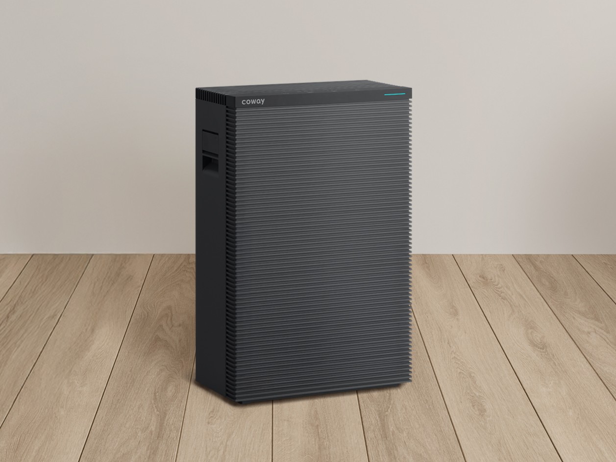 집안에 ‘스퀘어핏 공기청정기’가 놓여있는 사진입니다. 기존 대비 부피 최대 48%, 바닥 면적은 약 30% 줄어들며 공간 효율을 강화했습니다. 0.01μm 극초미세먼지를 99.999% 제거하며 에어매칭필터가 탑재되어 사용 환경에 따라 최적의 필터를 선택할 수 있습니다. 자동 풍량 조절, 초절전 에코모드, 저소음 취침모드 기능이 탑재되었으며, 위생 관리 편의성을 높이기 위해 정전기 방지 소재를 적용하고 토출부 및 프리필터는 분리 세척이 가능하도록 설계했습니다.